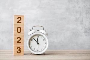 Happy New Year with vintage alarm clock and 2023 block. Christmas, New Start, Resolution, countdown, Goals, Plan, Action and Motivation Concept photo