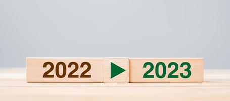 2023 y 2022 bloque de madera sobre fondo de mesa. resolución, estrategia, cuenta regresiva, objetivo, cambio y conceptos de vacaciones de año nuevo foto