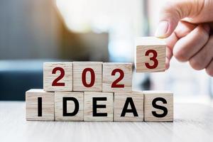 hand flipping block 2022 to 2023 IDEA text on table. goal, Resolution, strategy, plan, motivation, reboot, business and New Year holiday concepts photo