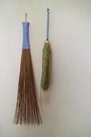 duster and broom stick hanging on the wall of the house photo