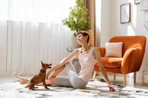 Woman doing yoga with her dog, enjoy and relax with yoga at home, relax photo