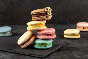 Macaroons stacked on a dark background. Delicious French cuisine dessert creatively decorated photo