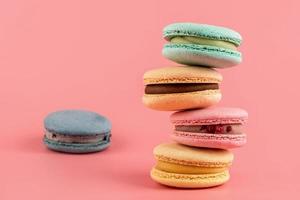 Macaroons stacked on a pink background. Delicious dessert of French cuisine, creatively decorated photo