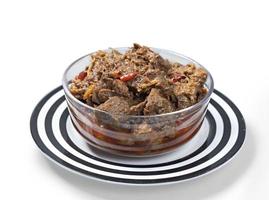 Traditional Beef Curry Served in trasparent bowl front view on ceramic plate photo