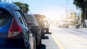 Close up tail light of blue car. Cars lined up in an orderly queue on asphalt roads. Clear traffic on the other side during daytime. Countriy road of Thailand. photo