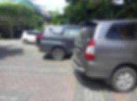 Defocused abstract background of   Seen several cars parked on the paving block road during the day photo