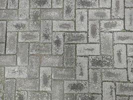 Old paving block with black sand dust on it when it just finished raining. Looks like a patterned background photo