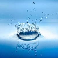 water splash with reflection and drops on a blue background photo