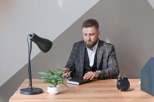 hombre de negocios, director ejecutivo llenando el bloc de notas de papel, planificación empresarial foto