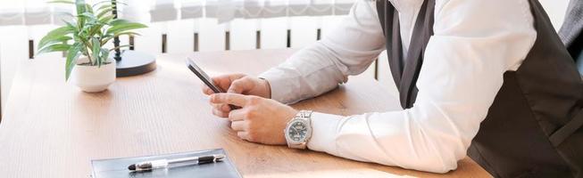 Happy businessman at his desk in office talking on phone. A young businessman photo