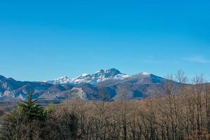snow capped mountains with blue sky photo