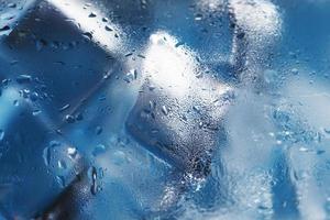 Ice cubes in a misted glass with drops of ice water close-up macro. Soft Selective Focus photo