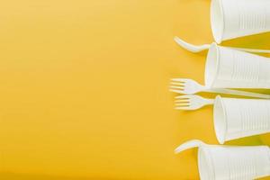 Plastic tableware on a yellow background with free space. photo