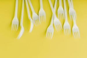 Plastic tableware on a yellow background with free space. photo