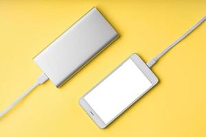 Smartphone and power bank on a yellow background isolate. photo