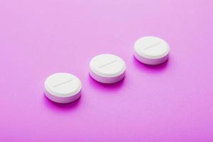 Ecstasy pills in a row on a pink background, isolate. photo