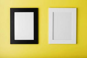 Two frames White and black photo frame on yellow background with free space.