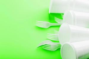 Plastic dishes on a green background with free space. photo