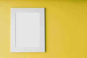 White photo frame on yellow background with free space.