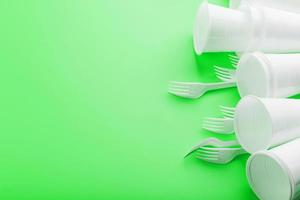 Plastic dishes on a green background with free space. photo