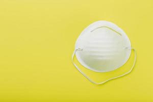 A mask to protect your breath from air pollution or an outbreak of flu or virus on a yellow background. photo