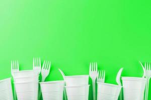 Plastic dishes on a green background with free space. photo