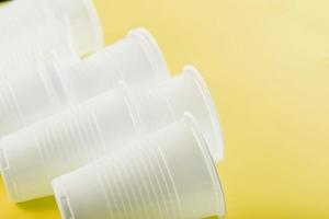 Disposable plastic tableware on a yellow background with free space. photo