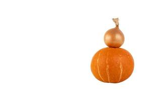 One yellow onion and an orange pumpkin are stacked in the form of a pyramid, white isolated background. photo