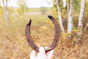 Old horseshoes, collected with a metal detector, against the background of an autumn forest. photo