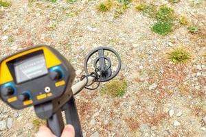 un hombre con un detector de metales en la orilla de un embalse. foto