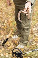 Man with electronic metal detector device working on outdoors. photo