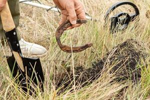 Man with electronic metal detector device working on outdoors. photo