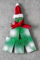 Electronic printed circuit boards in the shape of a Christmas tree with a red scarf and Santa hat on a light background. photo