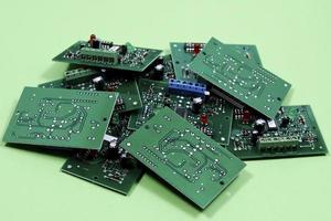 Electronic printed circuit boards on a green background. Recycling of electronic waste photo