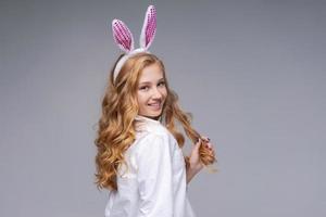 Cute beautiful girl wearing cute pink easter bunny ears, with impatience photo