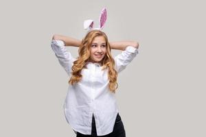 Girl in rabbit ears on her head against backdrop studio. Cheerful suffering photo