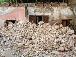 The remains of the demolished building are a pile of bricks and a wall with a door. photo