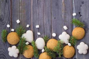 Christmas border with gingerbread, marshmallow and branch of fir tree photo