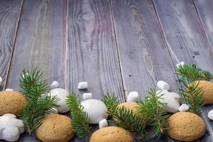 Christmas border with gingerbread, marshmallow and branch of fir tree photo