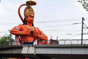 gran estatua de lord hanuman cerca del puente del metro de delhi situado cerca de karol bagh, delhi, india, lord hanuman gran estatua tocando el cielo foto