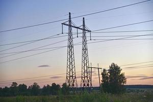 Beautiful high-voltage iron transmission line in the evening in the sunset sky. Landscape evening and wires and power lines. photo