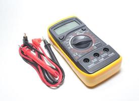 Digital multimeter with probes and display on a white background photo