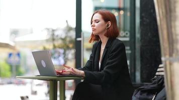 une femme d'affaires aux cheveux rouges travaillant à l'extérieur video