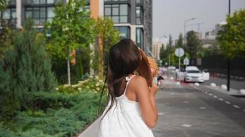 Woman in a flowy white dress walking on the street video