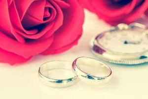 Red rose and wedding ring on white photo