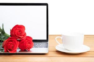 Red rose and coffee cup with laptop mockup on white photo