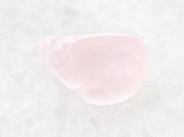 polished rose quartz gemstone on white marble photo