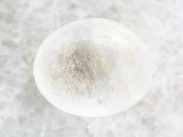 piedra preciosa de ágata blanca pulida en mármol blanco foto