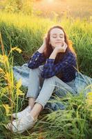 Portrait of a beautiful young woman on meadow photo