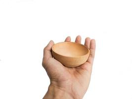 the hand holding a small bowl of wood insulated on a white background.photographed from the front photo